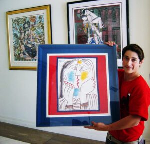 NorthStar Moving long distance mover holding up an original Picasso painting before carefully packing it for a client.