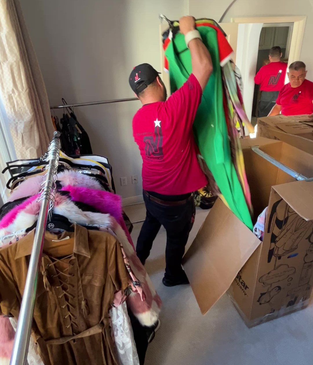 Luxury Movers NorthStar Moving packing up a client's closet using a wardrobe box.