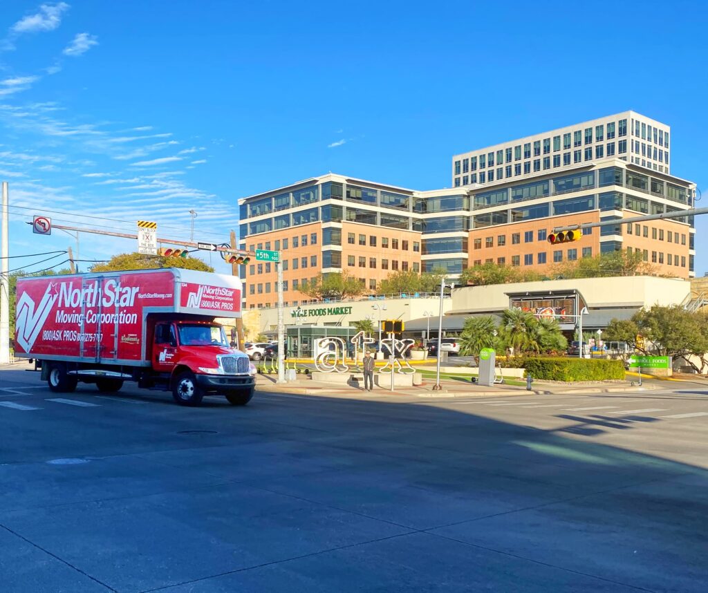 NorthStar Moving Austin movers driving in downtown Austin near ATX sign.