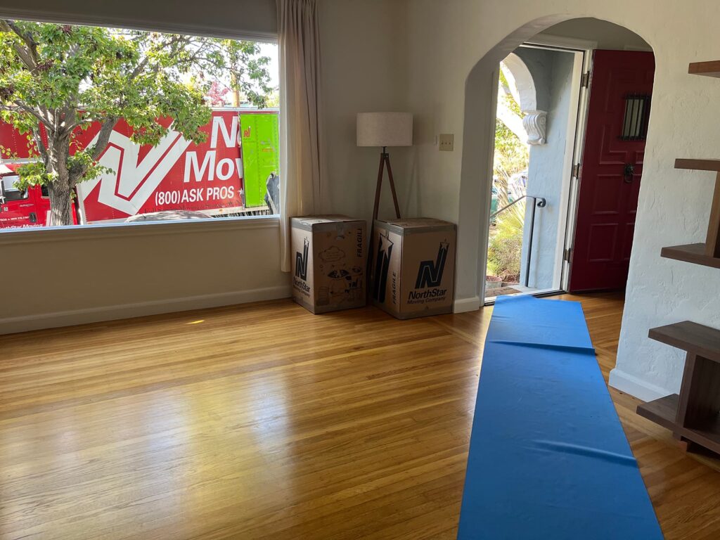 Long distance movers San Francisco: red moving truck outside, NorthStar Moving boxes ready by door.