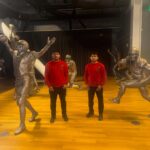 Two NorthStar Moving team members surrounded by bronze statues of 49ers players.