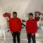 Two NorthStar Moving team members surrounded by displays of 49ers player uniforms