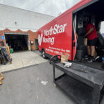 Donation bags collected by the Jones & Jones community as part of Move for Hunger's Multifamily program. A NorthStar Moving team member is loading them into our electric van, used to deliver them to the Hollywood Food Coalition.